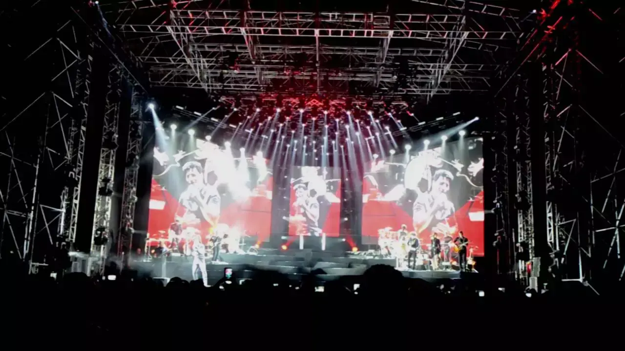 Band performing on a stage with dramatic lights at a live music venue