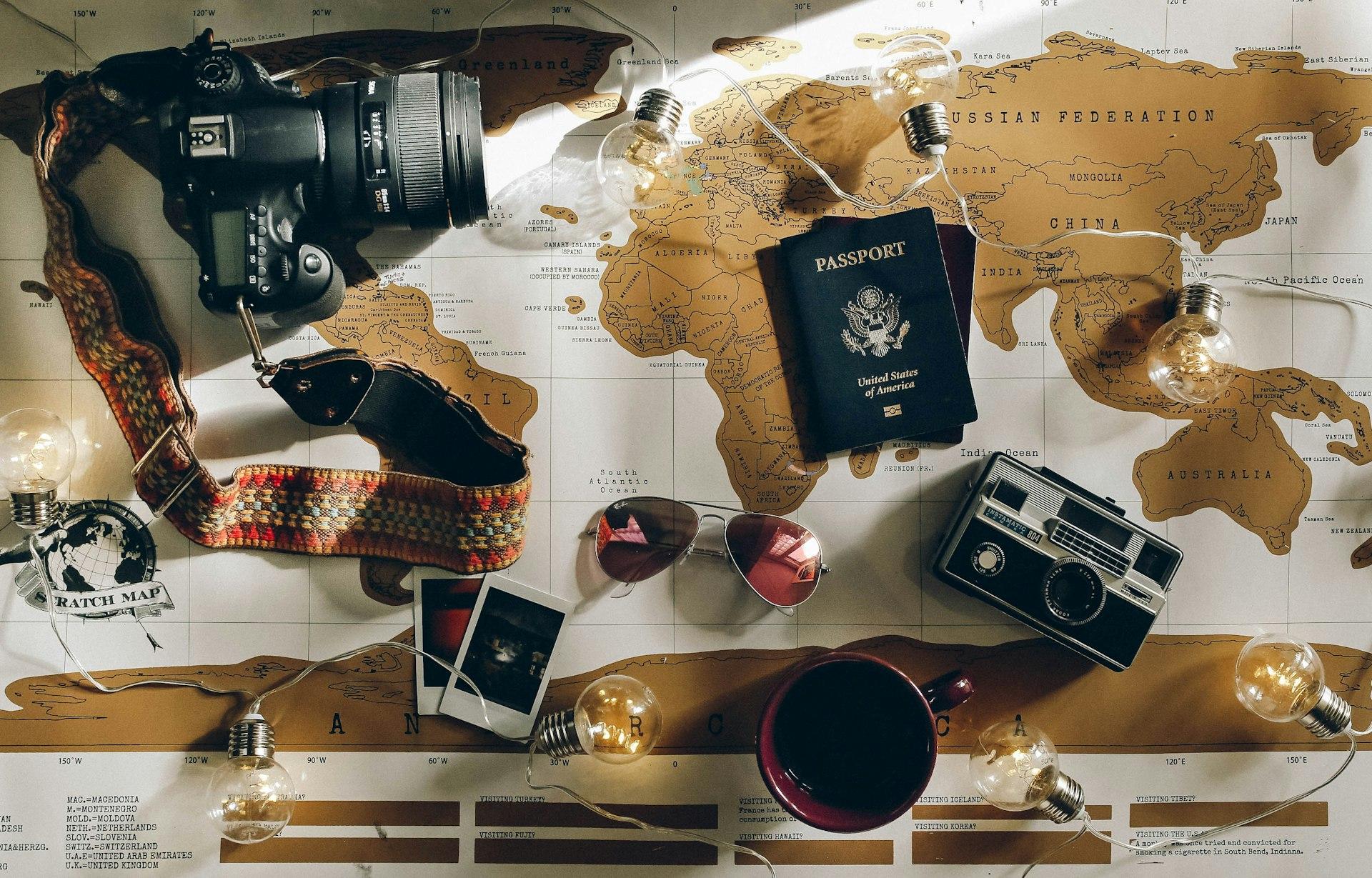 Travel flat-lay with passport, camera and world map