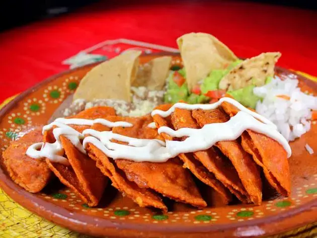Traditional Mexican breakfast plate with enchiladas, beans and guacamole
